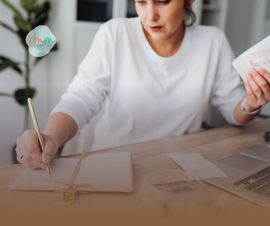 Woman organizing finances at home while creating a plan to pay off debt in a notebook.